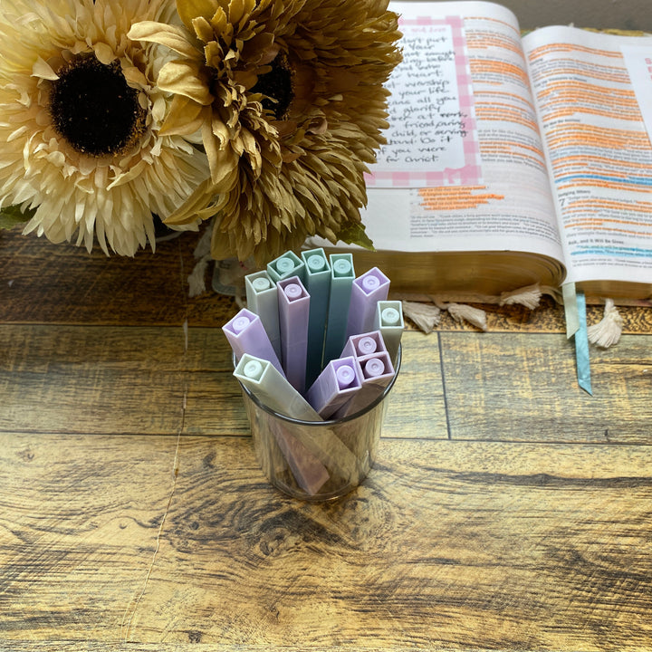 Open book with colorful markers and sunflowers on a wooden surface