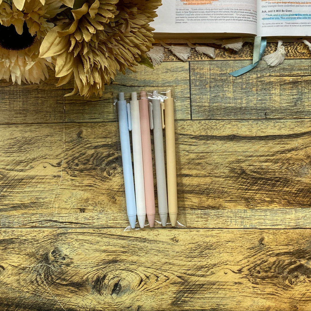 Open book with flowers and colored pens on a wooden surface