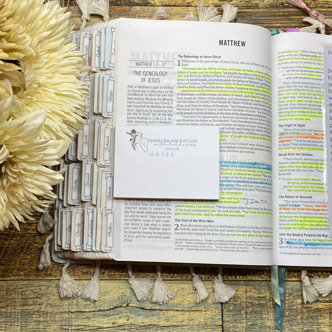 Open book with floral arrangement on a wooden surface