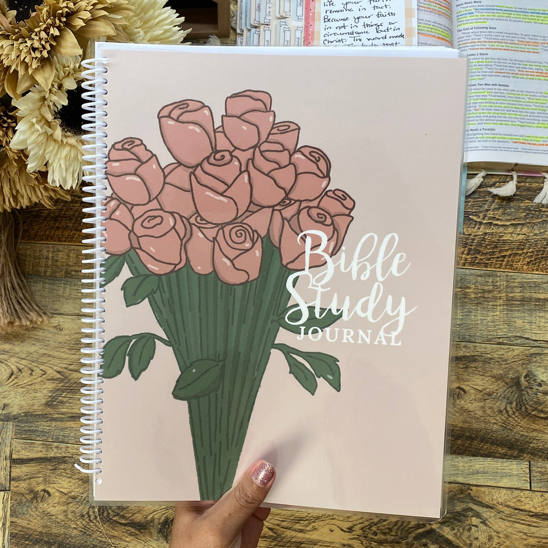 Bible Study Journal with floral design on a wooden table with printer and flowers in the background
