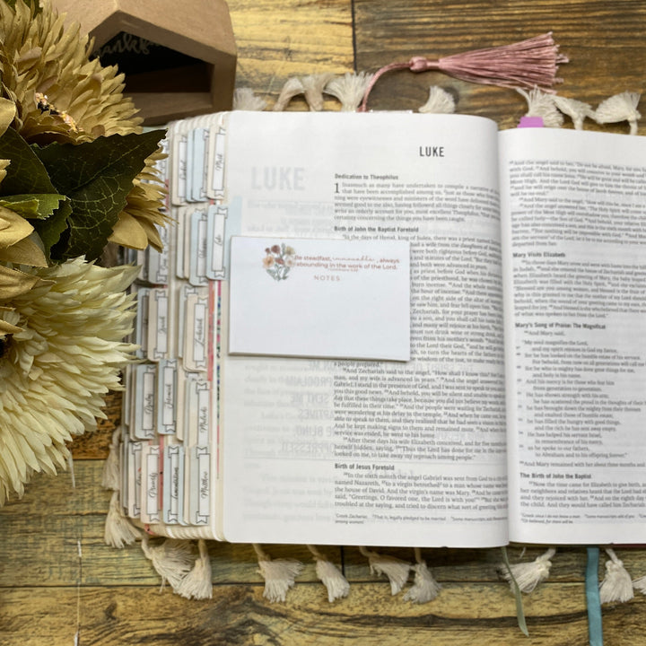 Open book with sunflower and decorative elements on a wooden surface