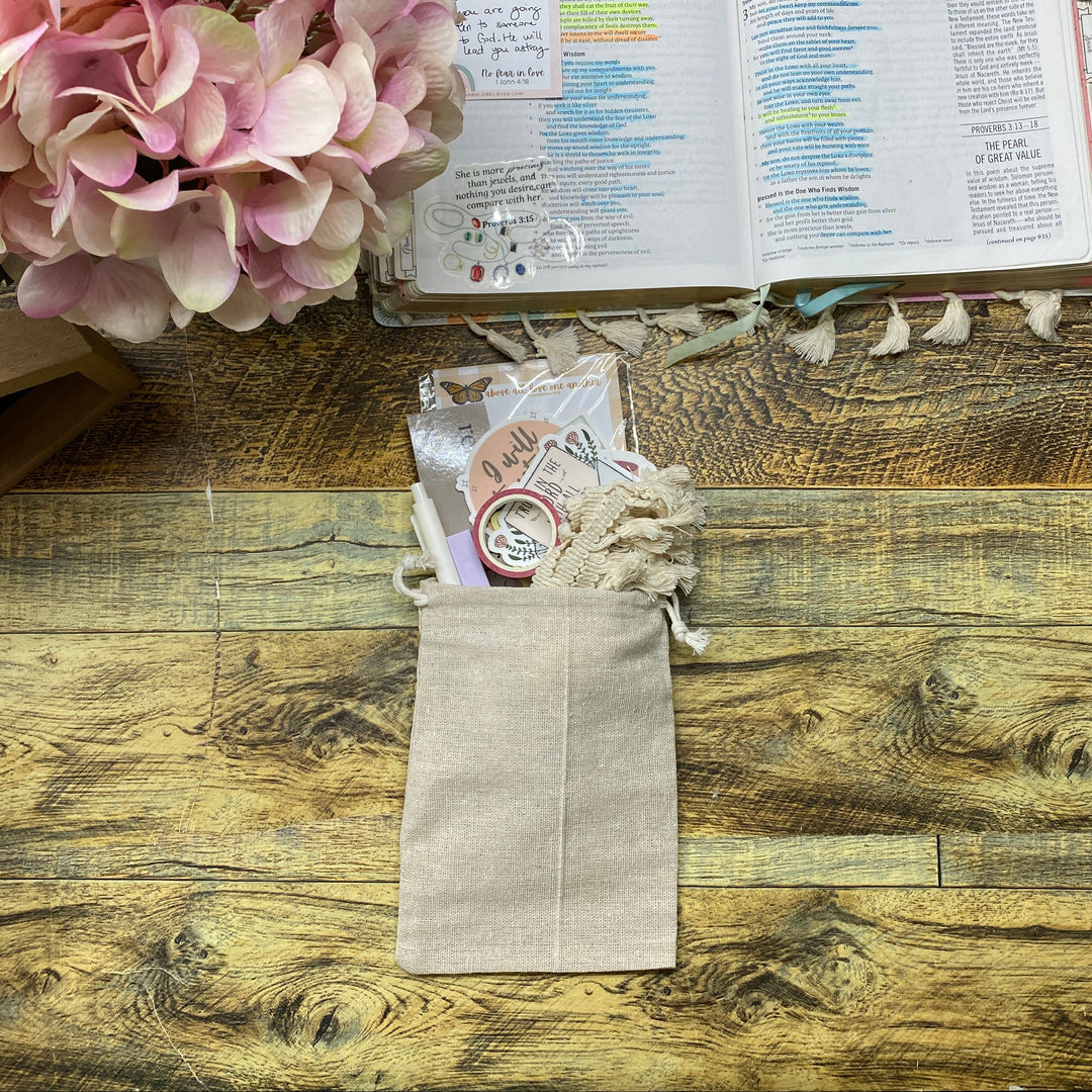 Wooden desk with pink flowers, an open book, and a small bag on top