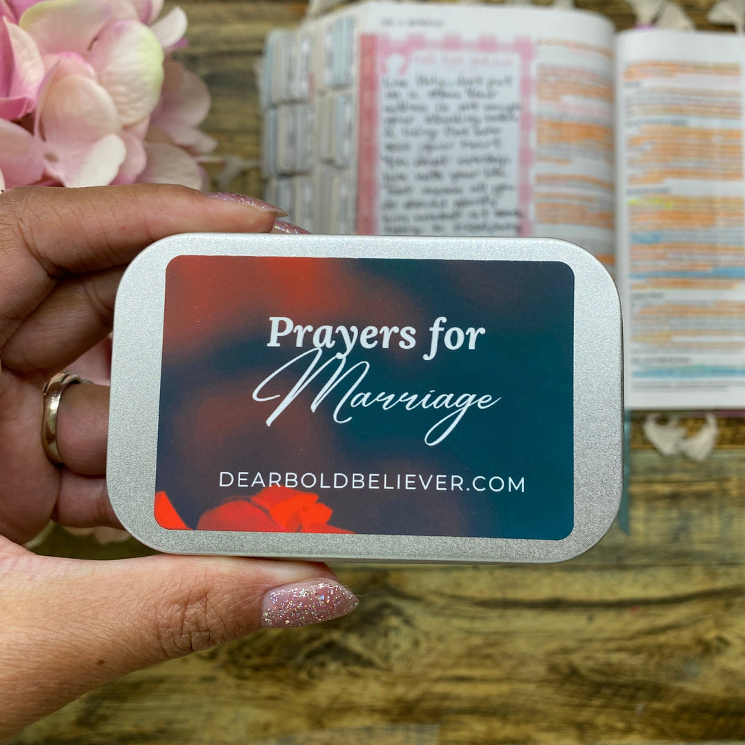 A hand holds a silver-bordered card labeled 'Prayers for Marriage' with the website DEARBOLDBELIEVER.COM on a dark blue and red gradient background.